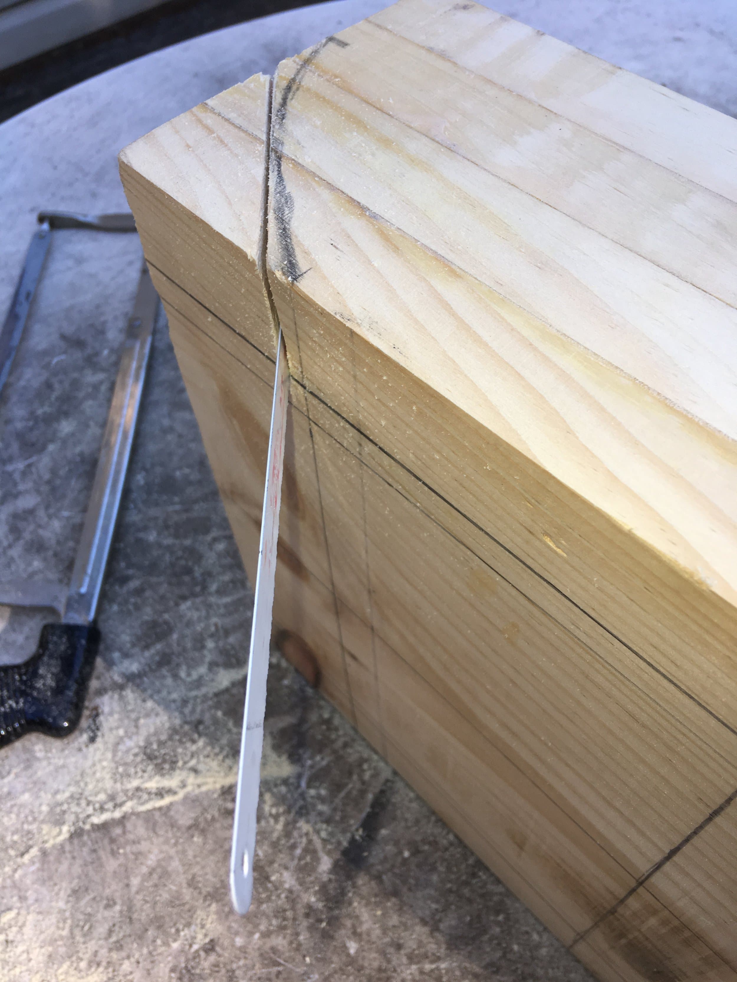 Cutting the rough shape with a hacksaw. Fully winging it here. After that I went at it with a belt sander.