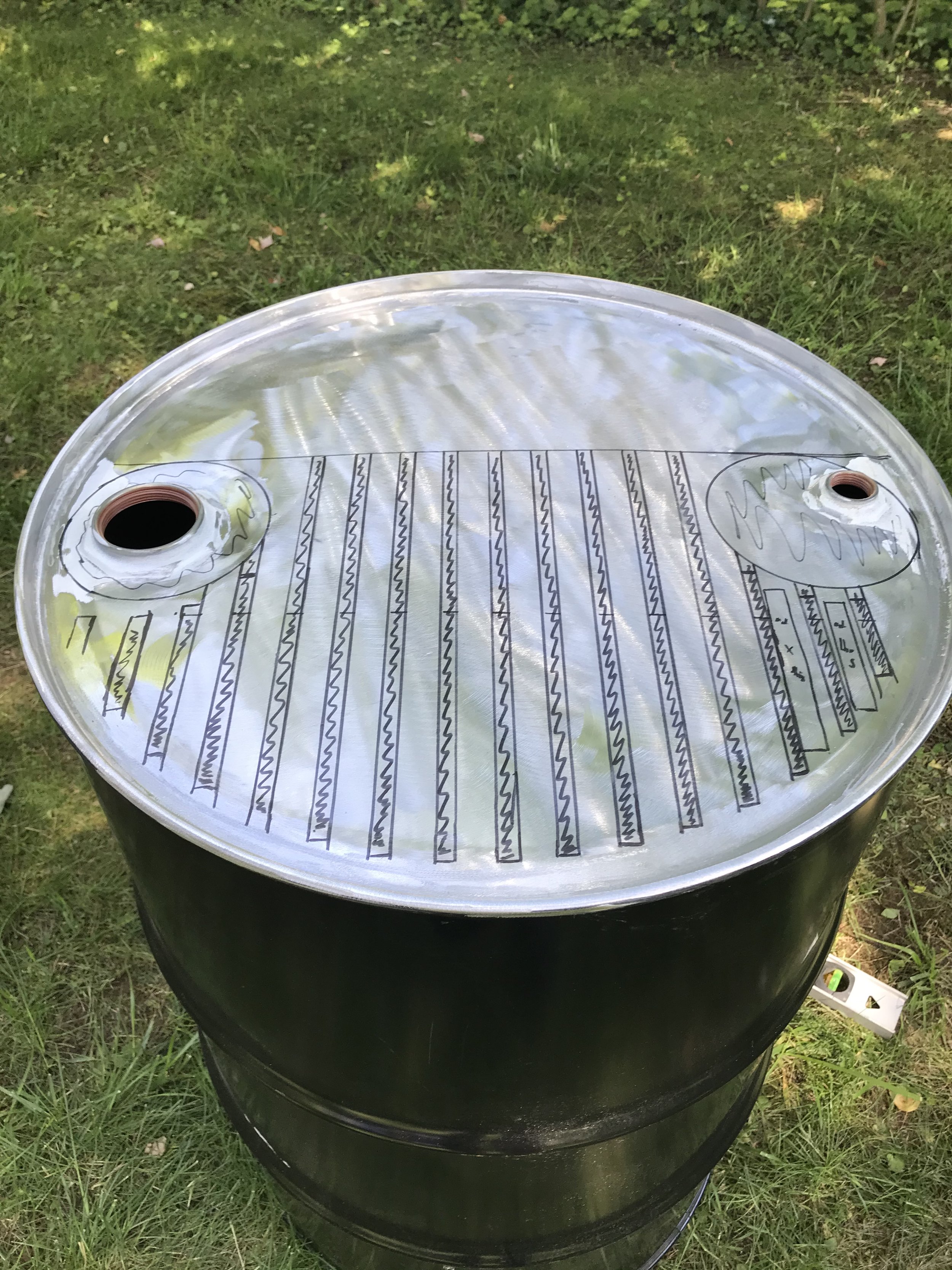 This was my first time wielding an angle grinder! I stripped the paint off the top of the drum and sketched out a design.